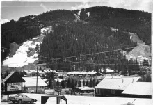 Red River's ski slopes above town in a black-and-white photograph from about 1980, the runs cut through the spruce forest above the rooftops.