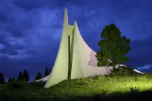 The Peace and Brotherhood Chapel at the Vietnam Veterans Memorial in Angel Fire, floodlit at dusk.