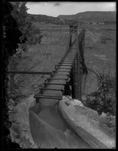 Water races down the wooden flume that carried Red River water toward the Elizabethtown gold workings, photographed about 1910 to 1920.