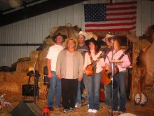 Western musicians pose on a hay-bale stage in Red River in 2008, heirs to the town's dance-hall music tradition.