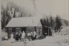 A settler family poses in front of the Melson-Oldham Cabin in Red River in an early-1900s photograph of the pioneer log home.