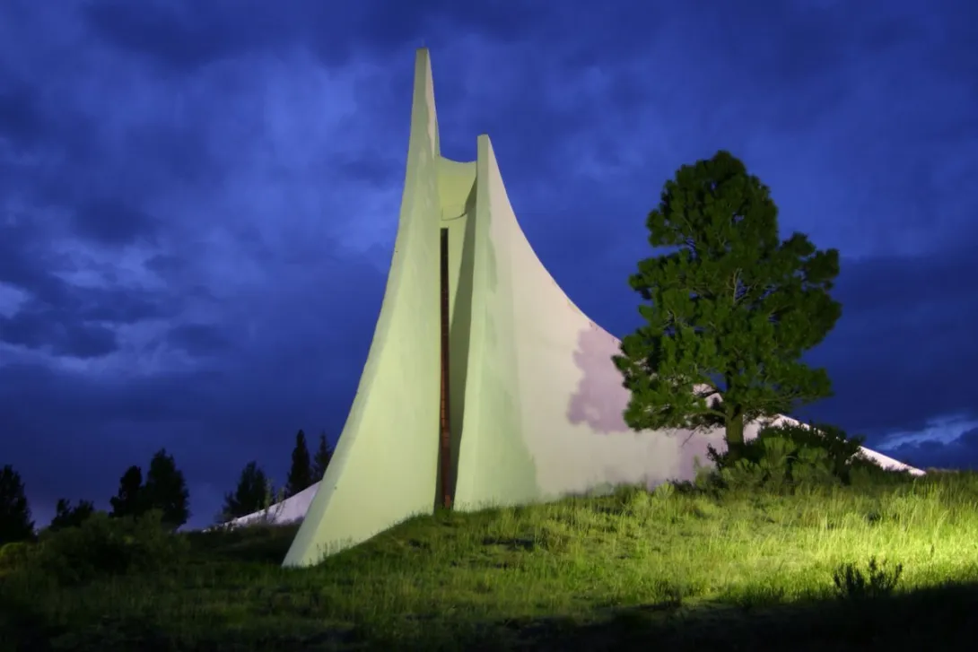 The Peace and Brotherhood Chapel at the Vietnam Veterans Memorial in Angel Fire, floodlit at dusk.