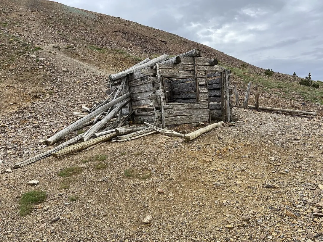 A collapsed mining-era log cabin on the rocky slopes of Baldy Mountain, above the Aztec Mine workings.